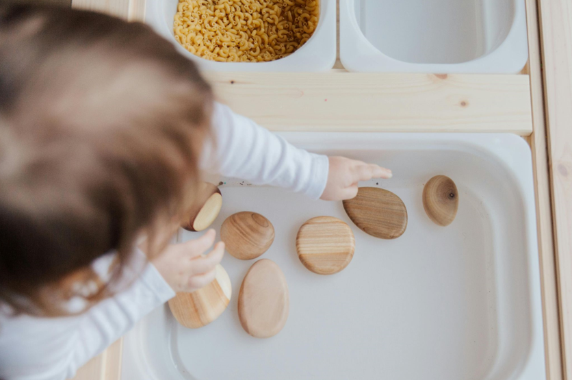 enfant_joue_avec_galets_en_bois